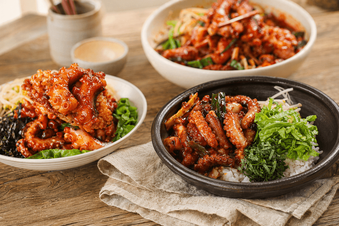 A Korean home meal spread with spicy seafood, broth, and pantry staples
